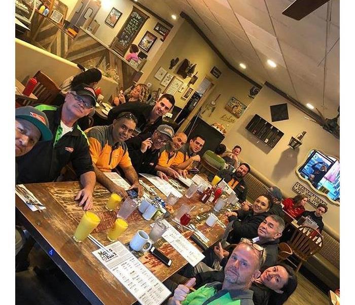 Group of people sitting down at a table for breakfast.